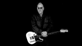 Mike Peters holding a Fender Telecaster, studio portrait