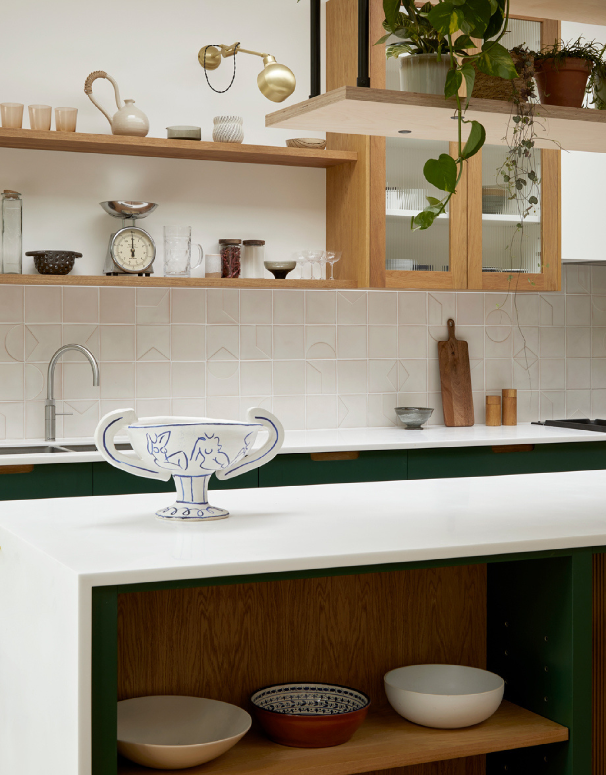 A charming kitchen with wooden cabinets, open shelves, a white counter, and ceramic bowls