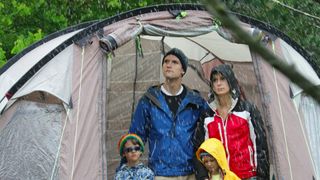 Family looking out from tent at rain