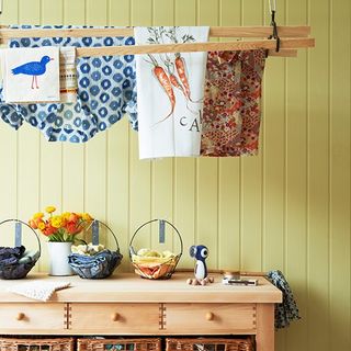 ceiling mounted airer with yellow wall and floral tea towel