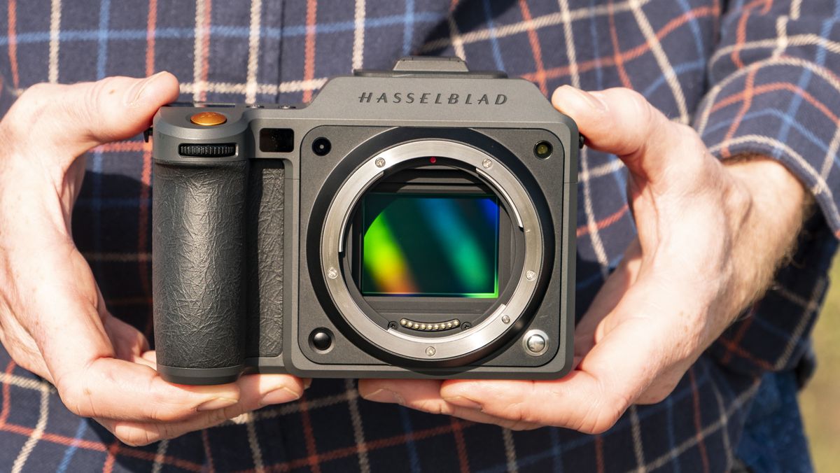 Hasselblad X2D II 100C camera in the hand, outdoors at first light