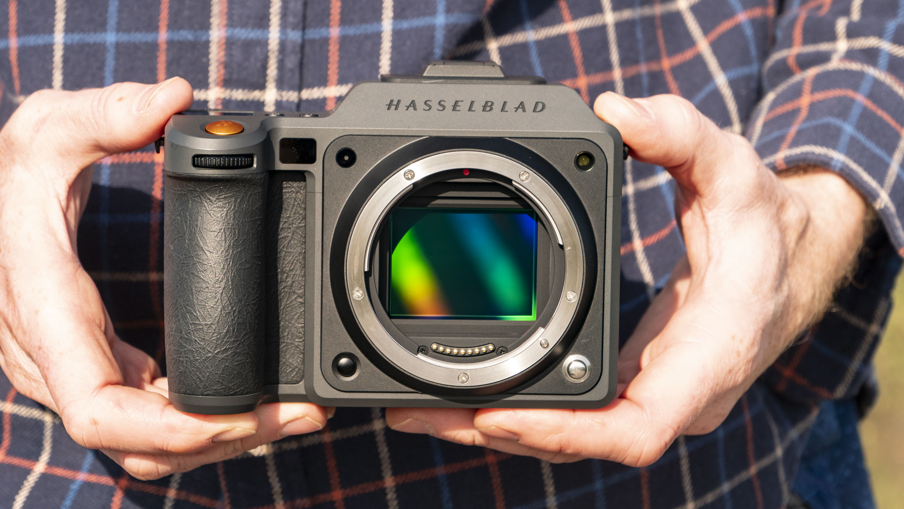Hasselblad X2D II 100C camera in the hand, outdoors at first light