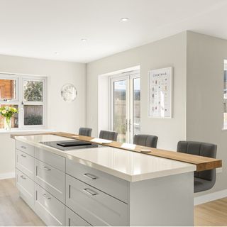 kitchen with wooden flooring, cashmere island and worktop and grey stools