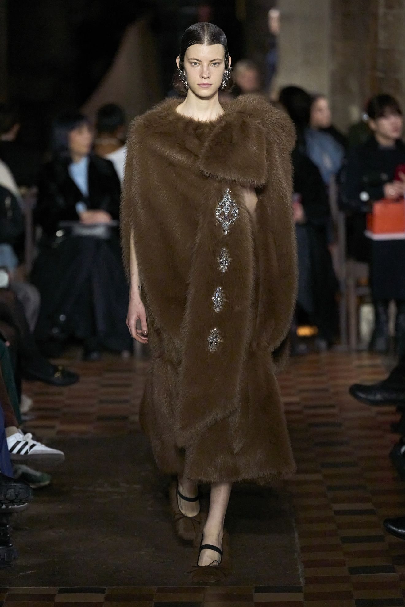 models wearing brooches on the runway