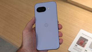 The Iris Google Pixel 9a held in hand, the photo taken downards to emphasize its color and size.