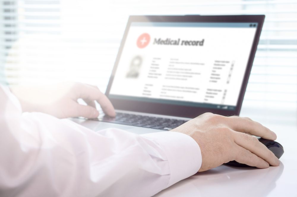 NHS doctor examining digitised medical records on a laptop