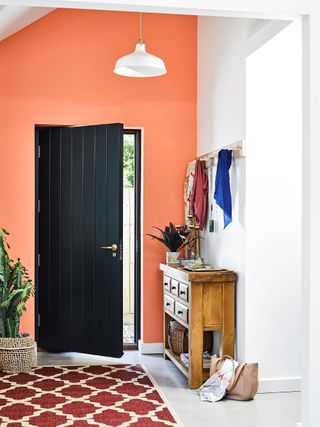 Peach coloured paint in a modern hallway with black exterior door