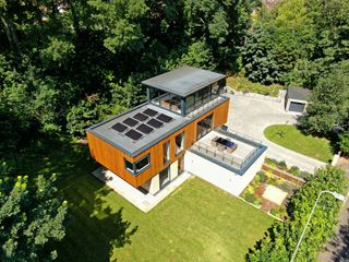 Solar panels sit on the roof next to a balcony