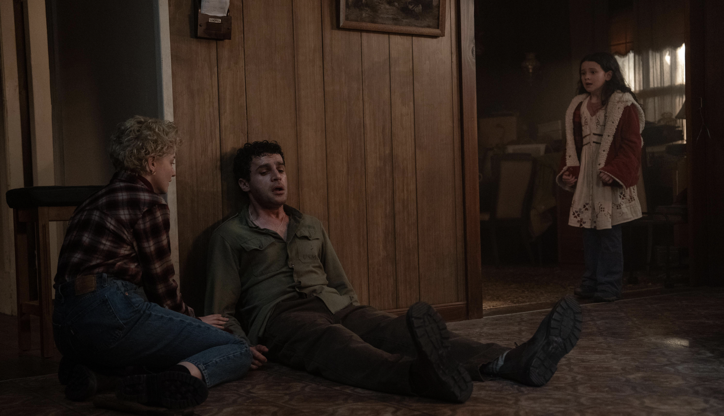 Julia Garner and Matilda Firth look scared as Christopher Abbott is slumped on the floor looking unwell