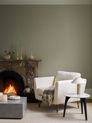 neutral color wall with direplace and white accent chair