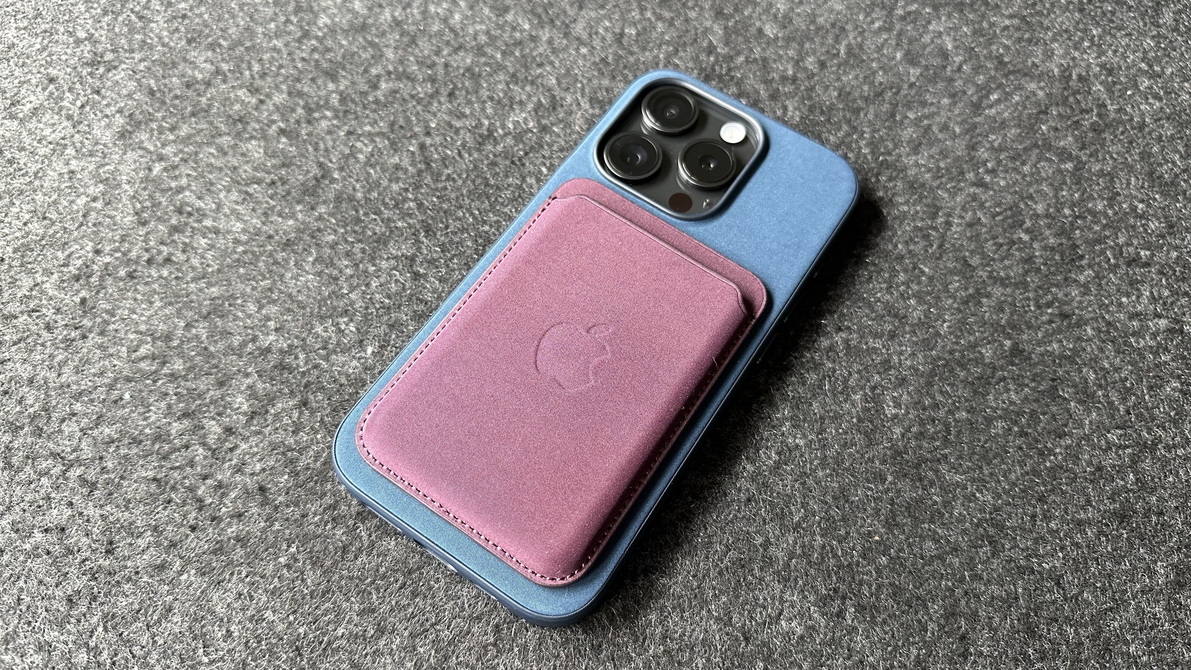 The iPhone 15 Pro with a Pacific Blue Apple FineWoven case on.