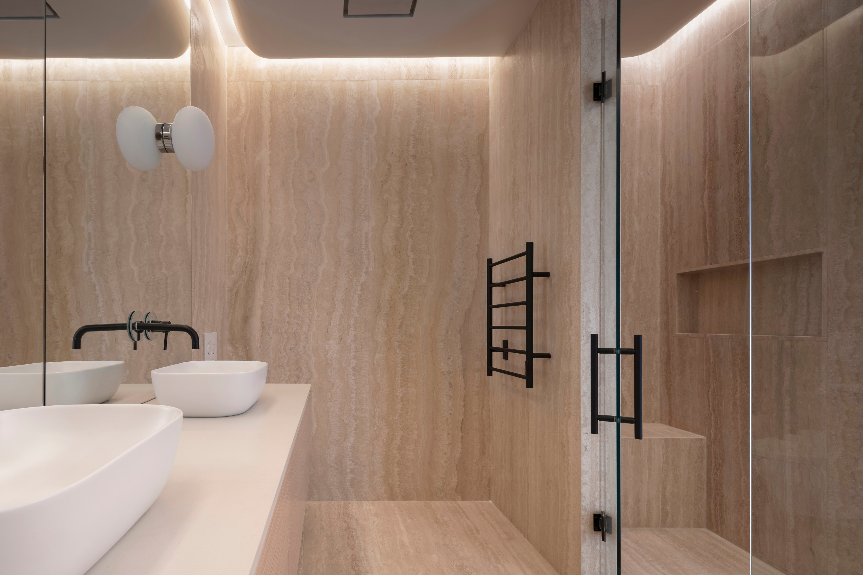 The bathroom is wrapped in Travertine
