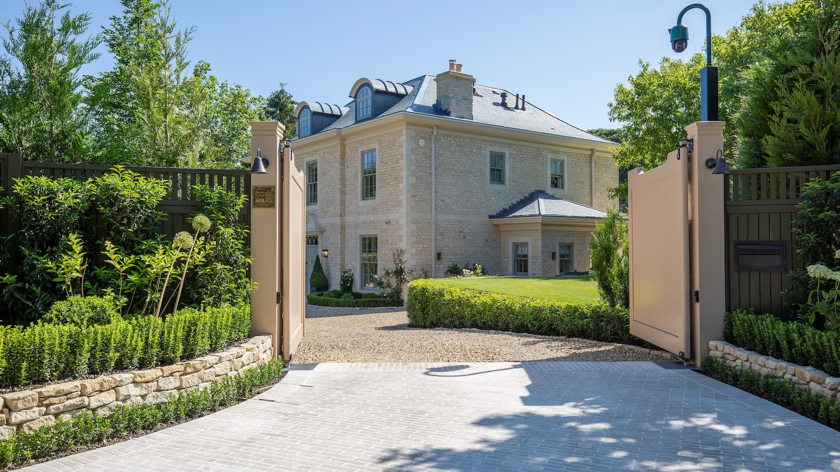 A herringbone paved driveway leading to a large property
