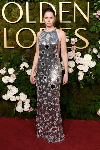 Felicity Jones at the 2025 Golden Globes in a silver dress with Chopard jewelry.