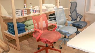 The low, mid and high-back versions of the Herman Miller Cosm chair next to a desk