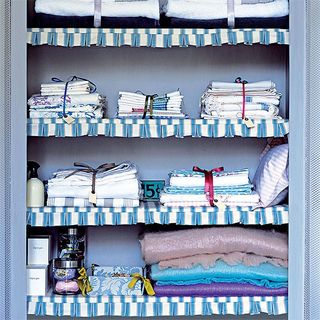 printed shelf with glass jars and clothes tied with ribbon