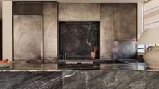 blackened steel cabinetry in a kitchen with dark, moody marble on the island and backsplash