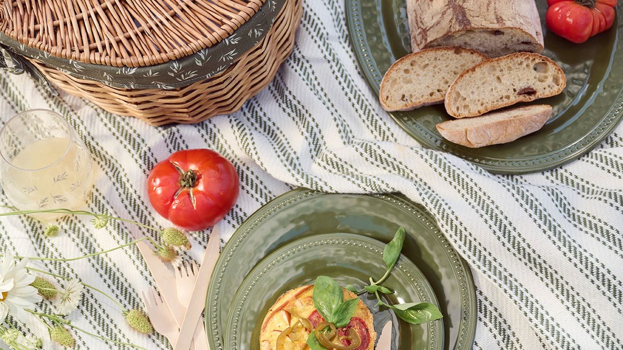 plates and bowls with food on them next to a picnic hamper on a blanket outside, Stacey Solomon&#039;s collection with George Home