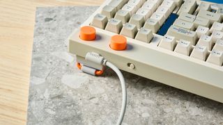 The Lofree Block keyboard on a stone surface with a blue wall in the background.