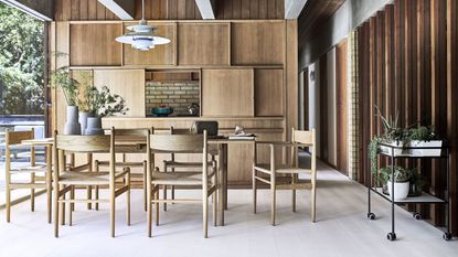 A dining room with wooden panelled walls and laminate floors