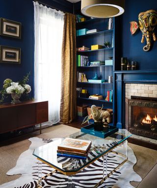 Teal living room with bookshelves and zebra print rug