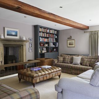 living area with fire place and grey colour book shelves and sofa with cushions