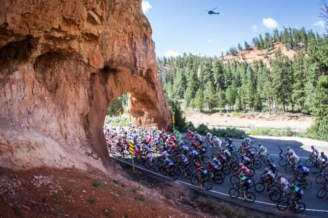 The peloton passes through arches on the way by Bryce Canyon