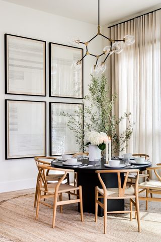 dining space with round dining table, wishbone chairs and jute rug by Lindye Galloway