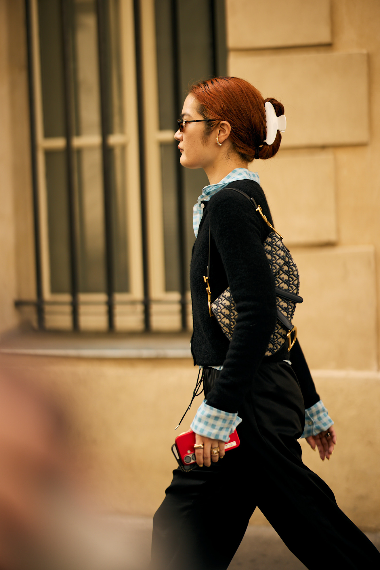 an asian woman in a black and blue outfit wearing red hair in a white claw clip