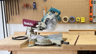 Matika mitre saw on wooden bench with tools hung up in background