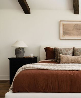 japandi style bedroom with ceiling beams and black nightstands