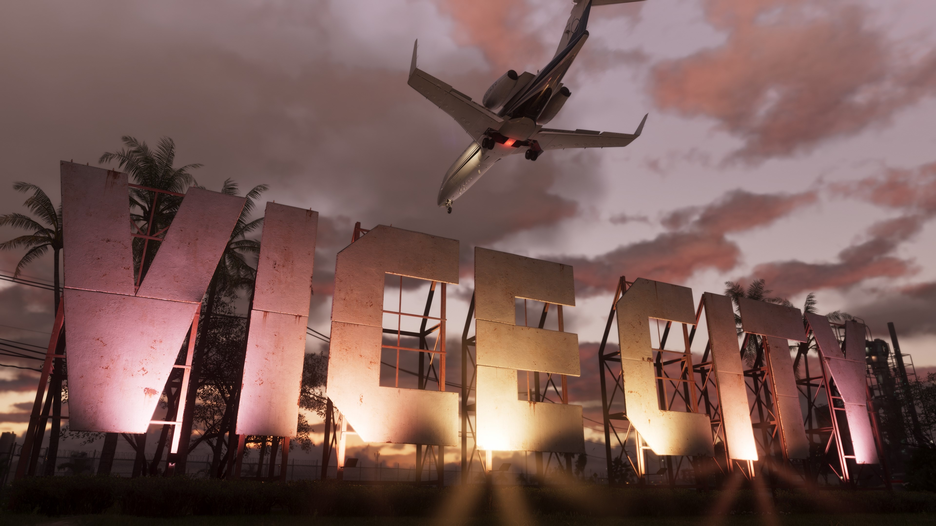 Large metal letters spell "VICE CITY" against a dusk sky with pink clouds. A jet plane flies overhead, creating a dynamic and bustling atmosphere.
