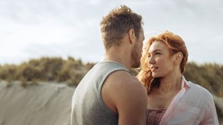 Evie and Danny looking into one another's eyes on the beach in The Couple Next Door episode 2