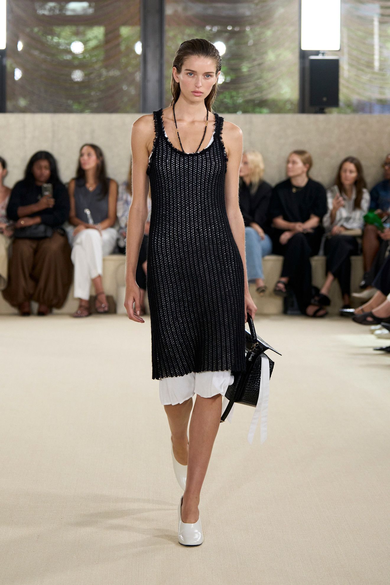 a Toteme model walks the spring 2026 runway wearing a black knitted dress with white high-vamp heels