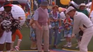 A scene with carnival games in the background on a wacky golf course in Caddyshack 2.