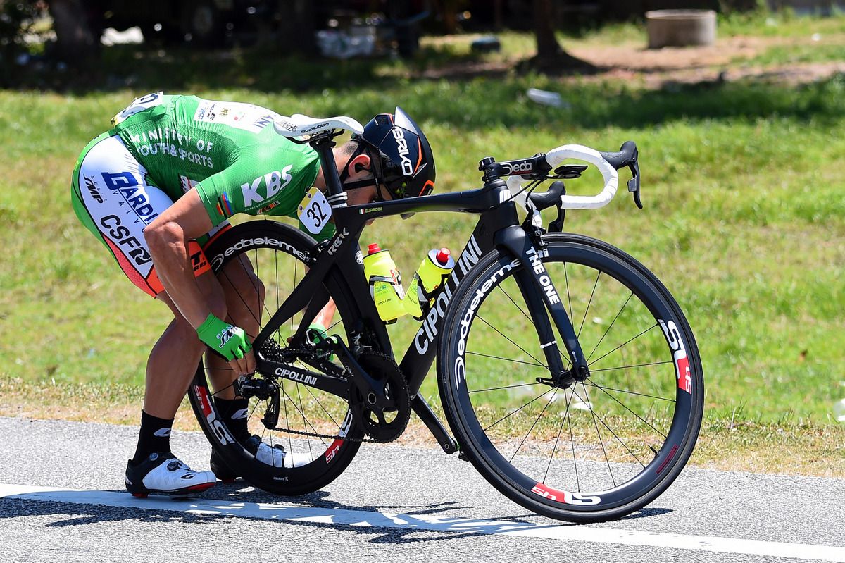 Andrea Guardini adjusts his bike after a mechanical
