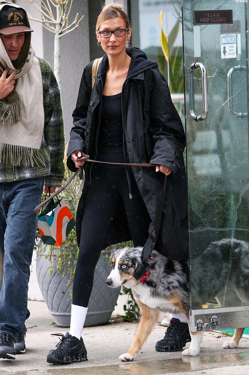 Bella Hadid wearing a black jacket and leggings with black Nike sneakers