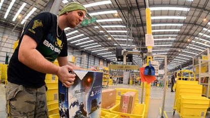 Employee collects orders at the Fulfilment Centre for online retail giant Amazon in Peterborough, England