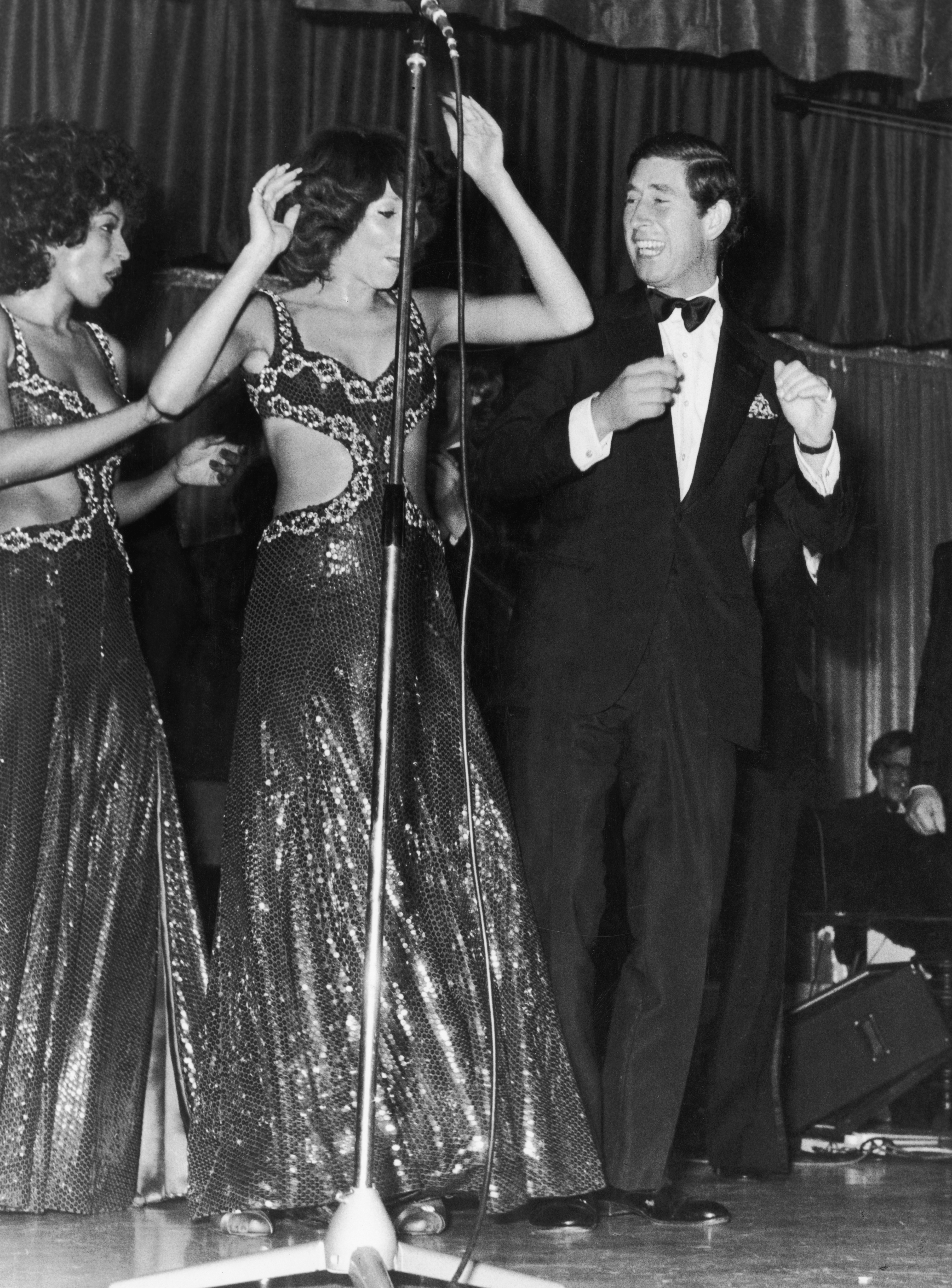 Prince Charles dancing on stage with two women