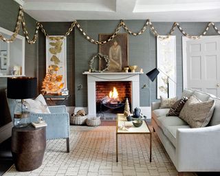 Christmas wall decor ideas with a gold and silver paper chain hung in a living room with grey walls and a fireplace