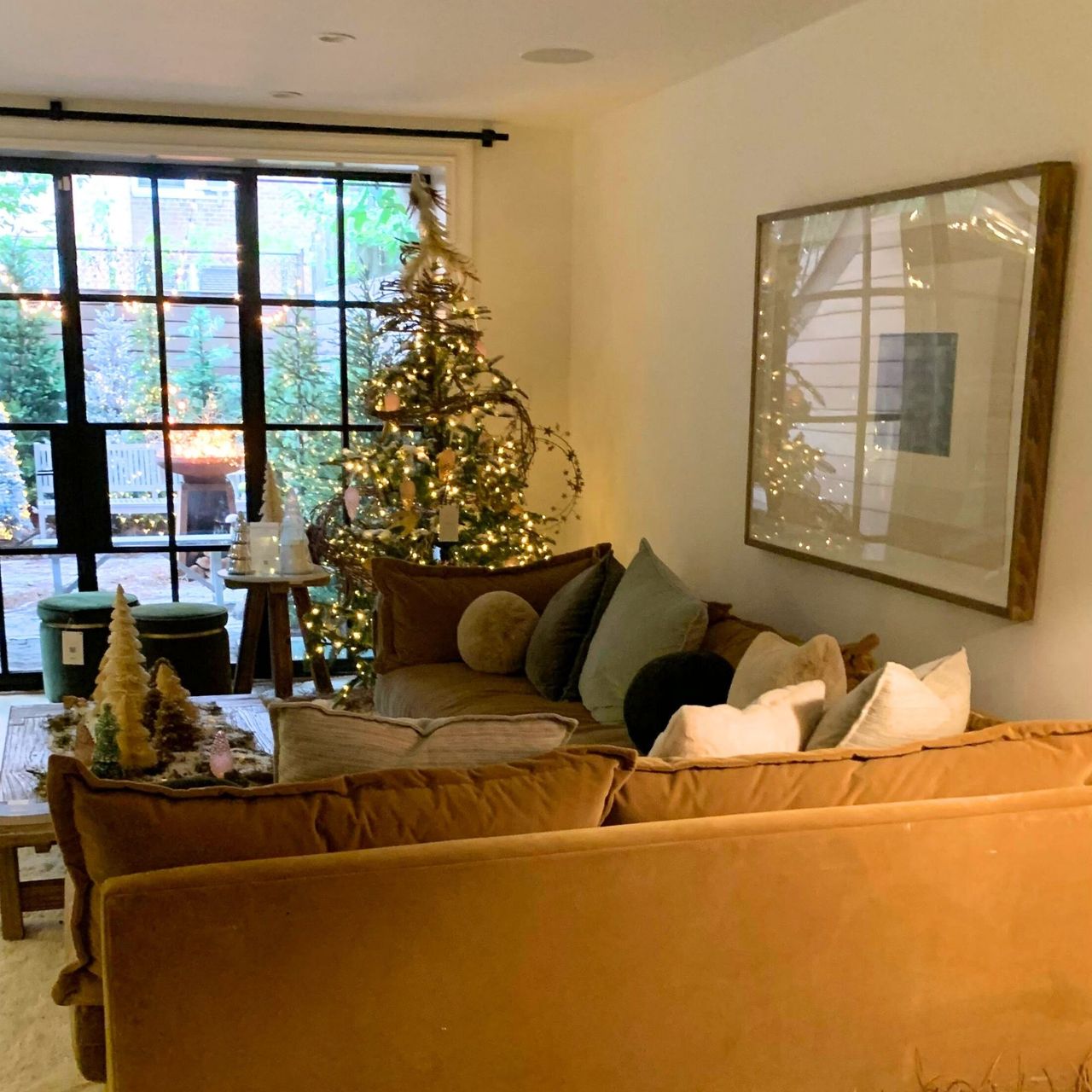 Anthropologie Holiday house den with cozy couch and christmas trees