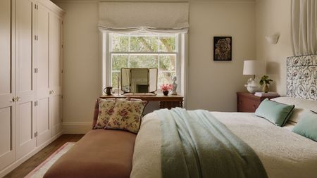 neutral london bedroom designed by Emma Ainscough with a wall of wardrobes and a canopy bed