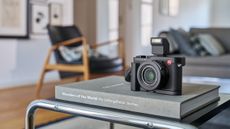 The Leica D-Lux 8 camera sat on a coffee table