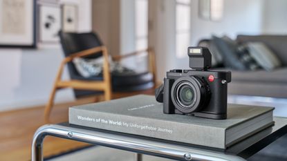The Leica D-Lux 8 camera sat on a coffee table