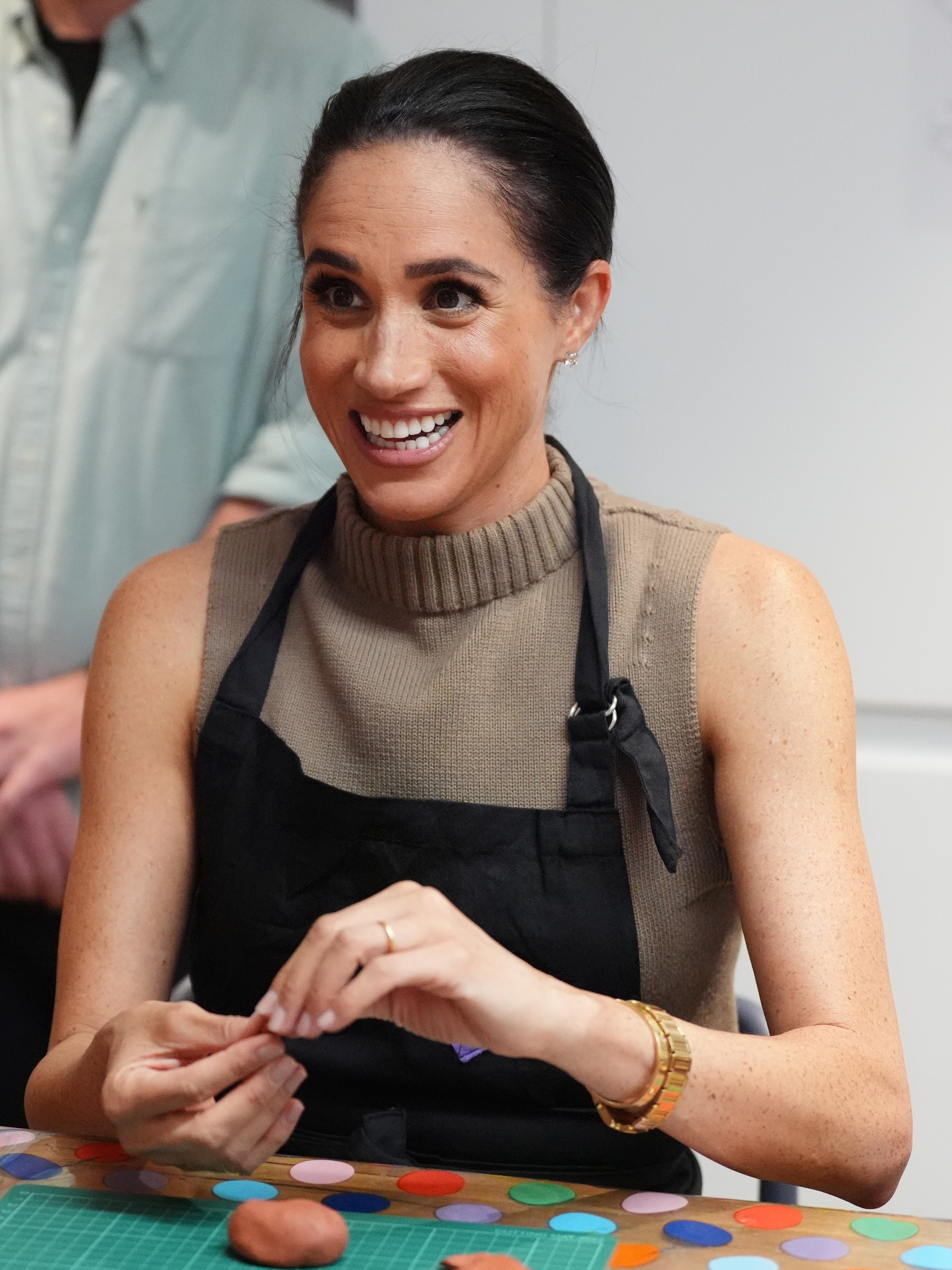 Meghan Markle wearing an apron making models at a table