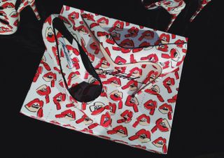 Red and white shoes covered in playful lipstick motifs