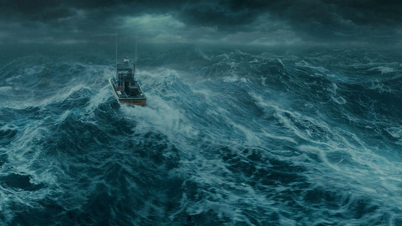 A lone boat rides waves in a wild ocean at night in a still from the movie The Perfect Storm.