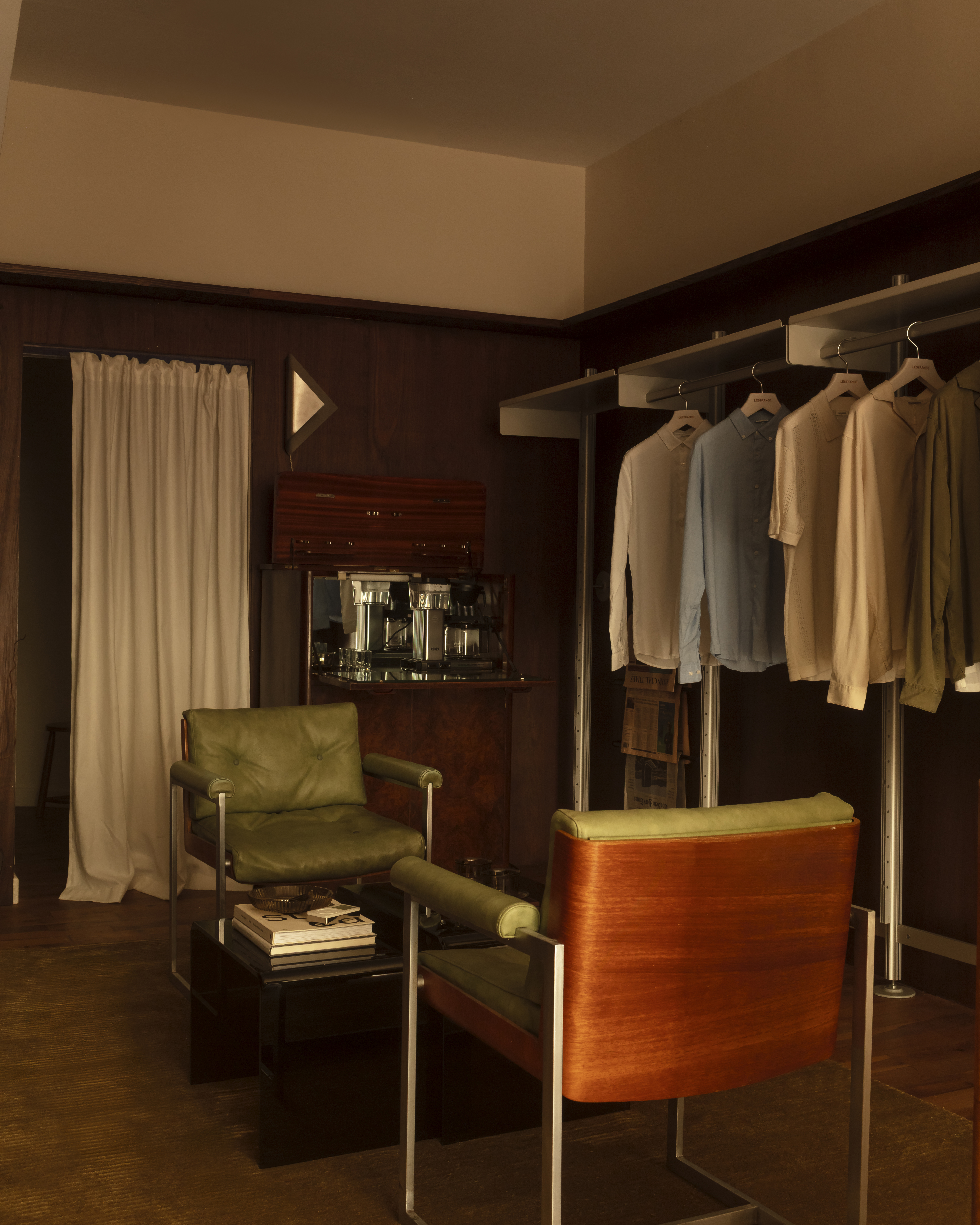 Different corners of a sleek menswear store clad in warm woods, beige drapery, and silver and mint green accents.