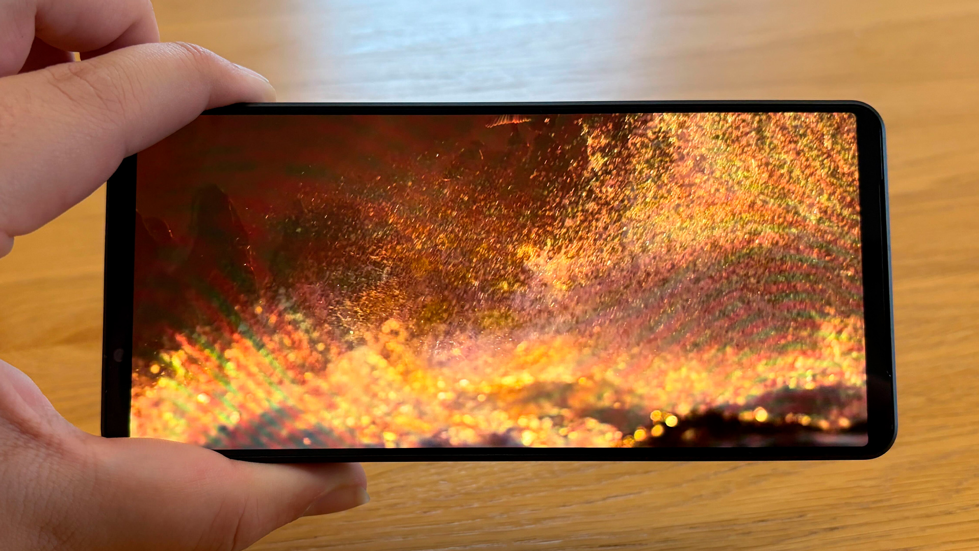 Sony Xperia 1 VII smartphone hel;d in hand with volcanic lava on screen