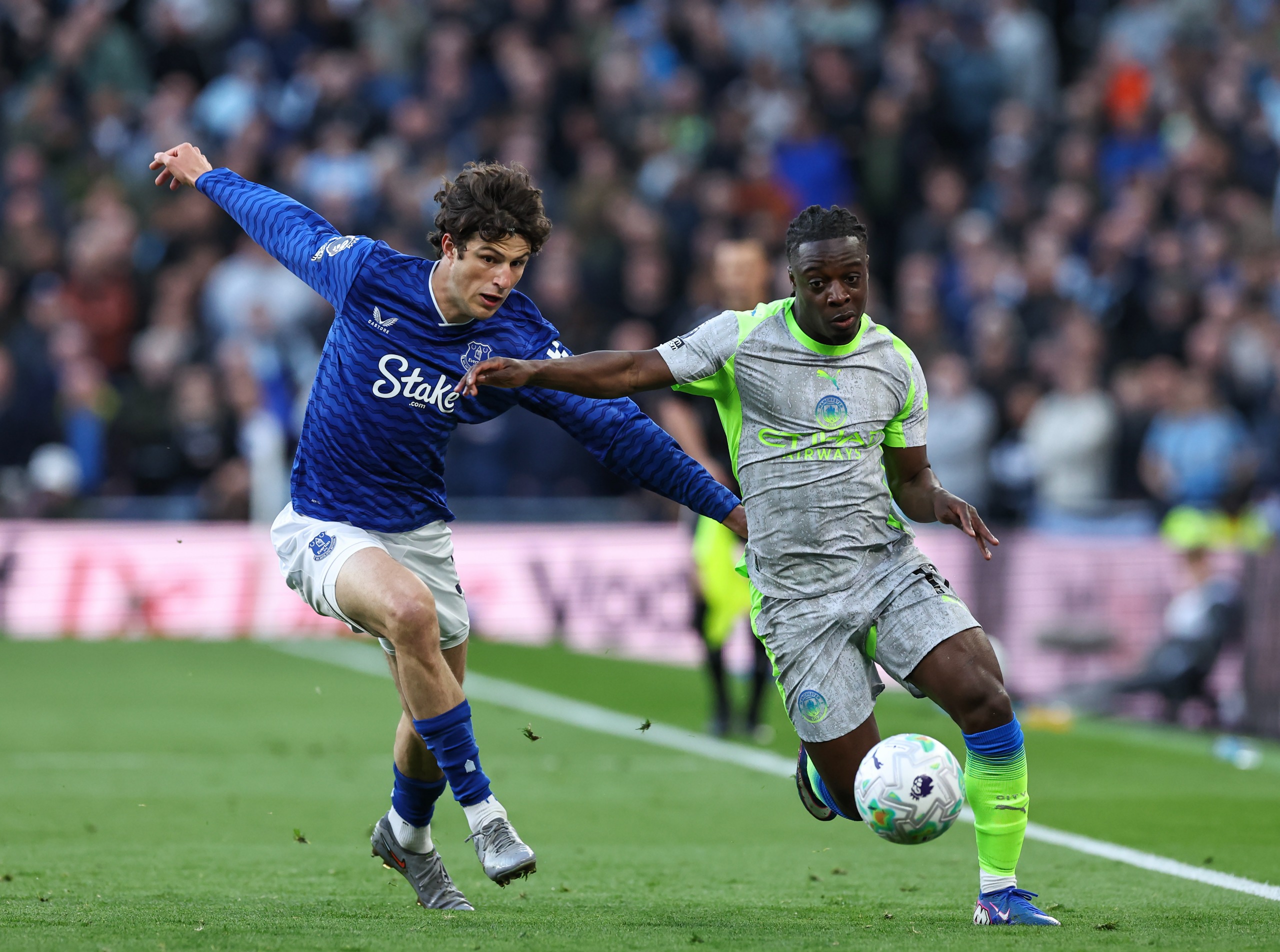 Manchester City's Jeremy Doku runs with the ball under pressure from Merlin Rohl